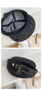 Detail of washed black denim hat with adjustable leather strap and golden metal buckle