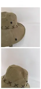 Detail of army green outdoor canvas hat with cross stitching and metal eyelets
