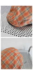Détail du motif à carreaux orange et de la texture en lin de coton de la casquette plate