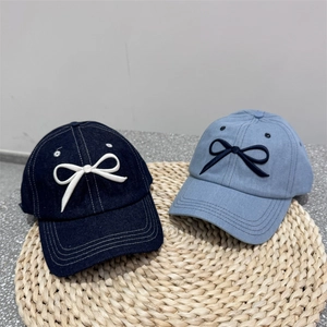 Denim baseball caps with embroidered bow in navy and light blue on straw mat