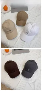 Flat lay of five cotton baseball caps with RH embroidery in various neutral colors