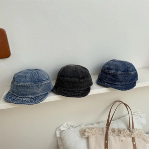 Three washed denim bucket hats in light blue, black, and dark blue on a white shelf