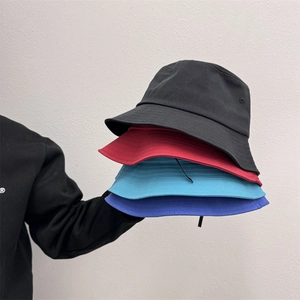 Pile di cappelli a secchiello in cotone colorato nero rosso e blu con tese cucite a più file