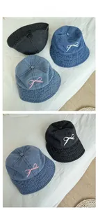 Three denim bucket hats in various blue shades with delicate bow embroidery detail