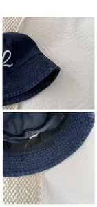Detailed macro view of 100% cotton denim bucket hat with white letter embroidery