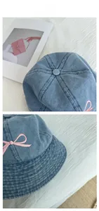 Close-up of blue washed denim bucket hat featuring pink bow embroidery details