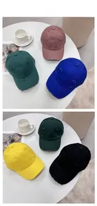 Flat lay of distressed vintage baseball caps in six colors on a white round table