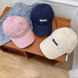 Three cotton baseball caps with Consice embroidery in pink, navy blue, and beige