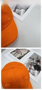 Close-up of bright orange vintage baseball cap with distressed torn brim and top eyelets