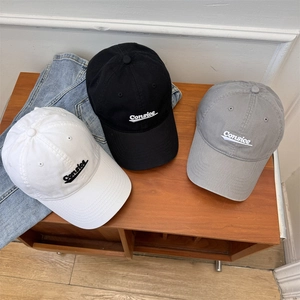 Three cotton baseball caps with Consice embroidery in white, black and grey on wooden shelf