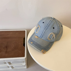 Vintage light blue distressed denim baseball cap with ripped brim and streetwear style
