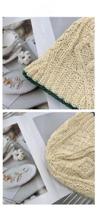 Détail du chapeau de soleil en maille beige avec une bordure cousue contrastée vert foncé