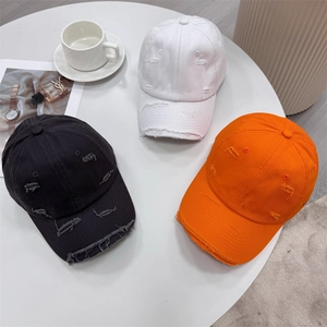 Vintage distressed baseball caps with ripped holes in black, white and orange street style