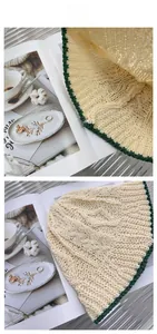 Détails de la maille et bord vert d'un chapeau cloche en paille beige pour l'été