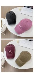 Tile display of washed denim baseball caps with bow embroidery in four colors