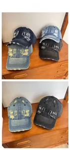 Detail of vintage washed denim cap showing distressed holes and frayed edge design