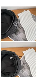 Detailed macro view of retro black denim beret featuring distressed logo patch and inner drawstring