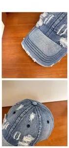 Detailed close-up of vintage blue washed denim baseball cap with distressed frayed edges
