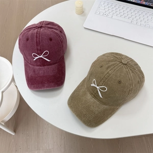 Washed denim baseball caps in burgundy and olive green with white bow embroidery