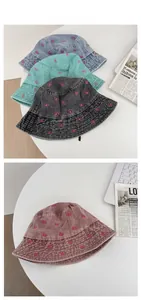Detail view of denim bucket hats with pink butterfly embroidery in four washed colors