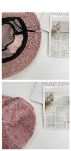Detail of pink denim bucket hat featuring butterfly embroidery and adjustable inner drawstring