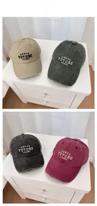 Detail of vintage washed cotton baseball caps with distressed brims and letter embroidery