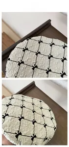 Detail of off-white beret with black bow accents and textured diamond pattern