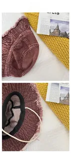 Detail showing distressed denim fisherman hat with frayed edges and adjustable inner strap