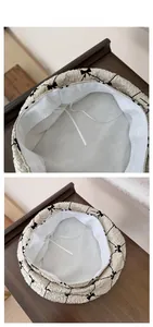 Detail view of cream beret featuring bow embroidery, inner mesh lining, and adjustable cord