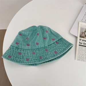 Teal denim bucket hat with pink butterfly embroidery and wide brim for sun protection