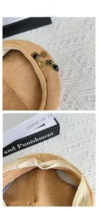 Detail of camel knit beret showing vintage metal badges and breathable inner sweatband
