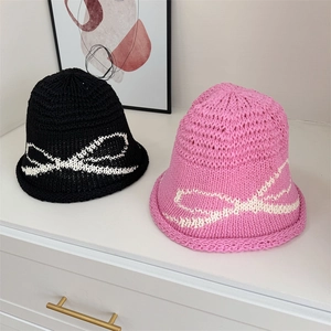Knitted bucket sun hat with large bow pattern in black and bright pink colors