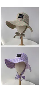 Detail of plaid sun hats with chin straps and woven logo label in various colors