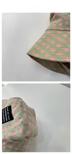 Detailed view of pink and green checkered bucket hat with stitch quality and side woven label