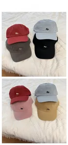 Detail view of cotton baseball caps showing embroidered fox logos in multiple colors
