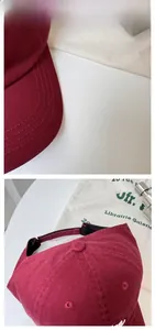 Detail of adjustable strap and stitching on a burgundy cotton baseball cap
