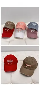 Detailed close-up of embroidered bow baseball caps with vintage distressed edge finish