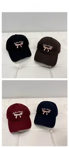 Detail of embroidered bow baseball cap with distressed brim in four vintage colors