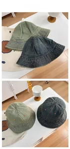 Detail view of vintage denim bucket hats featuring orange contrast stitching and embroidery
