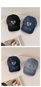 Detailed view of washed denim baseball caps with bow patches in black and blue colors