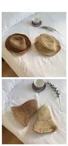 Detail view of woven straw sun hats with colorful braided edges and natural fiber texture