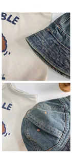 Detail of blue denim bucket hat with contrast orange stitching and retro texture