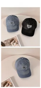 Detail of washed denim baseball cap with striped bow embroidery and premium texture