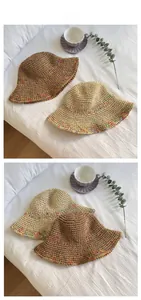 Flat lay of handmade straw bucket hats with rainbow stitching and wide sun brim