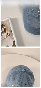 Detailed close-up of light blue washed denim baseball cap with white embroidery