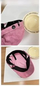 Detail view of pink corduroy newsboy cap showing fabric texture and inner lining