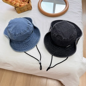 Washed denim bucket hat with frayed edges and adjustable windproof rope for sun protection