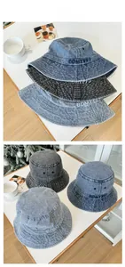 Detail of embroidered letters on retro washed denim bucket hats in multiple colors