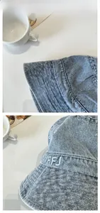 Detail of white NYFFJ letter embroidery and stitching on washed blue denim bucket hat