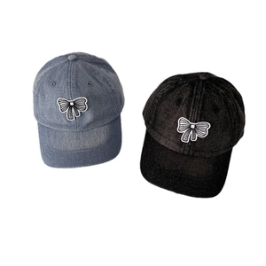 Washed denim baseball cap for women with bow applique in light blue and black denim